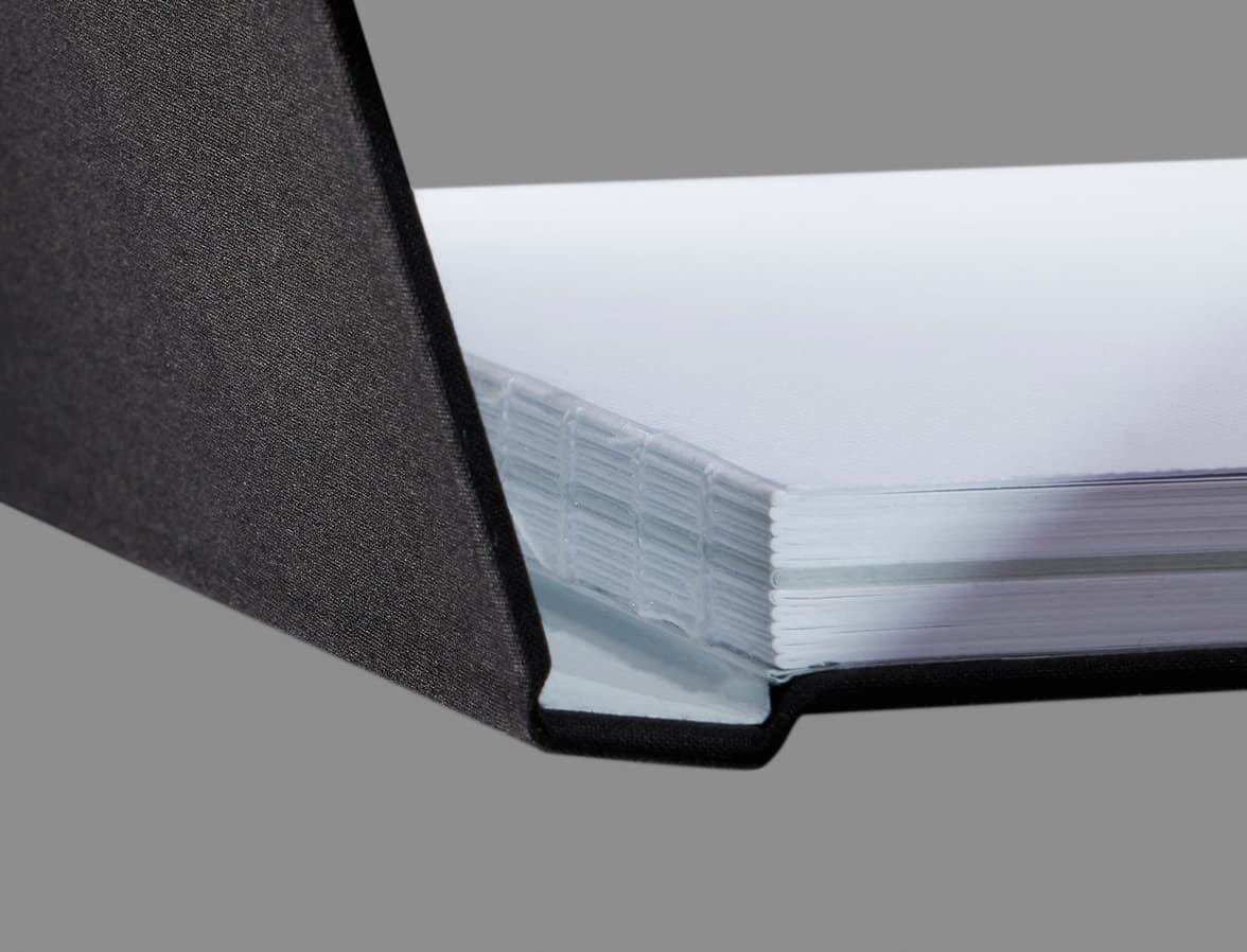 Detail image of the Swiss binding design on a grey hardcover notebook.
