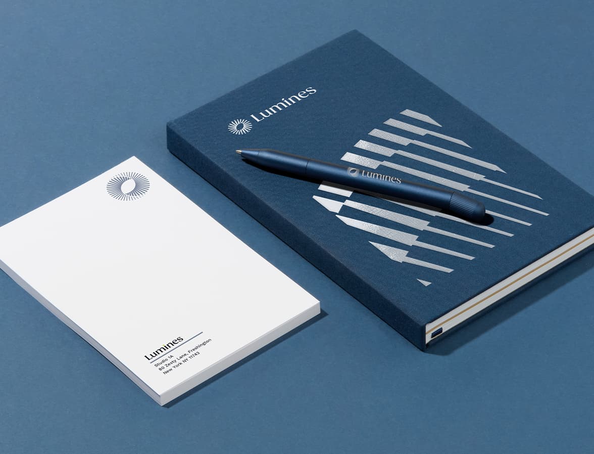 A collection of branded merchandise including a notebook, notepad and pen.