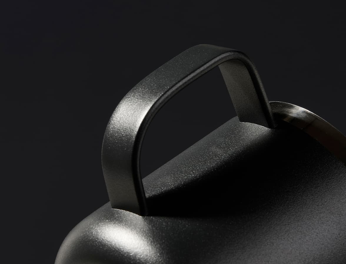 A close up image of the handle of the black insulated mug.