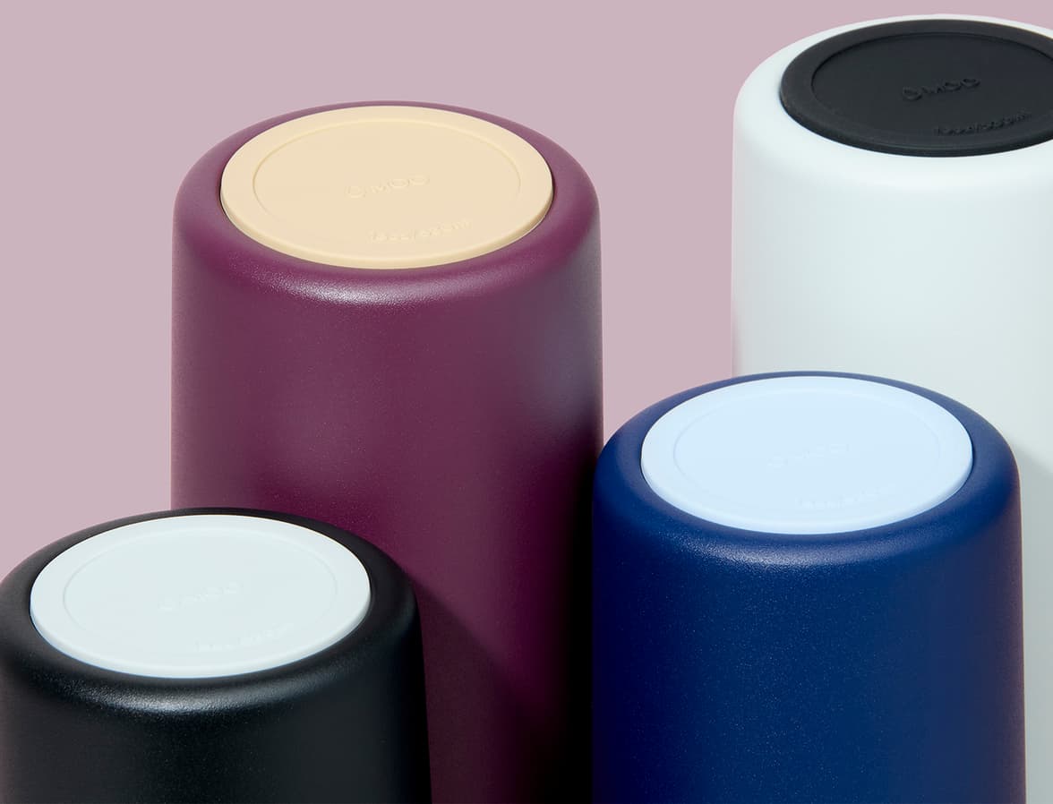 The bottoms of a collection of MOO water bottles focusing on the contrast of colour on the base.