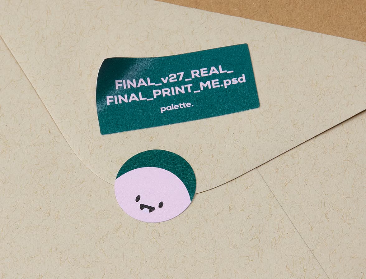 A round and a rectangular customized coated stickers placed on the back of an envelope.