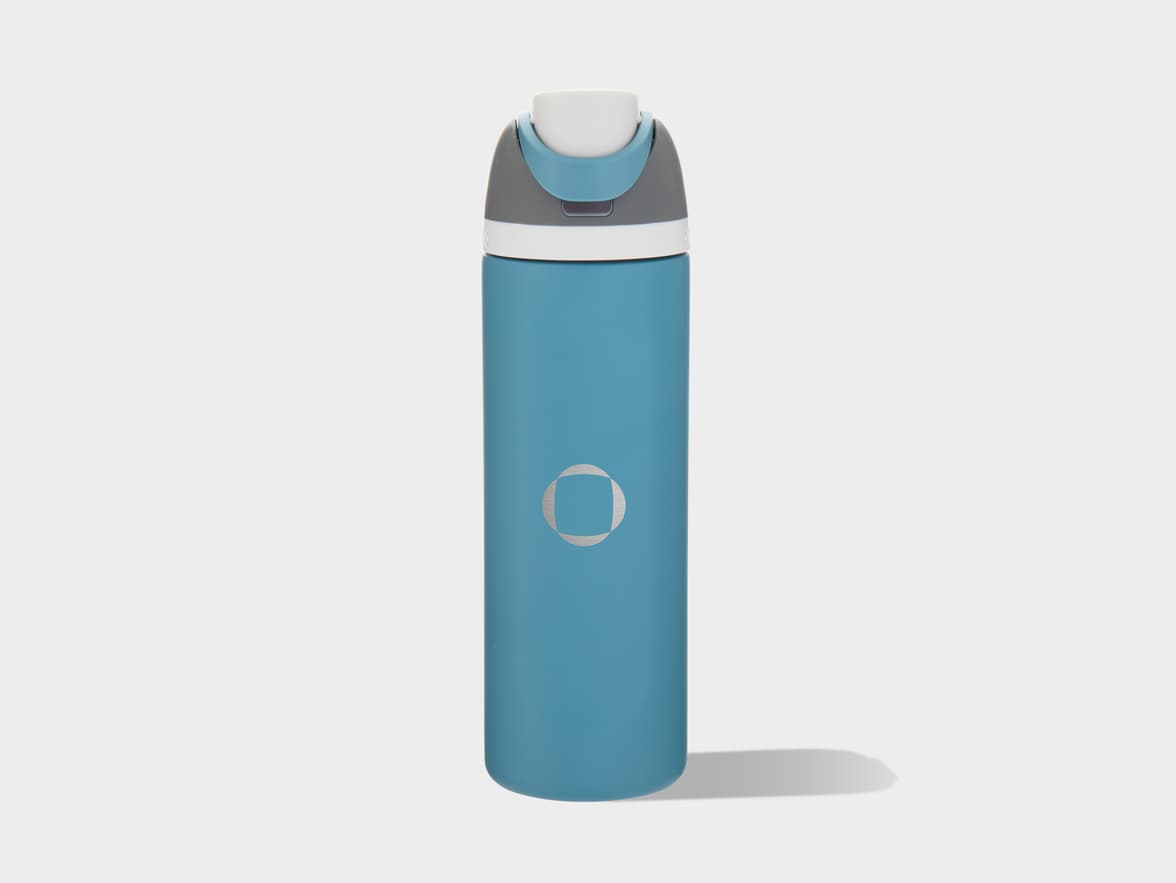 A teal bottle with a white, gray, and blue cap, featuring a silver stylized circular logo on its side.