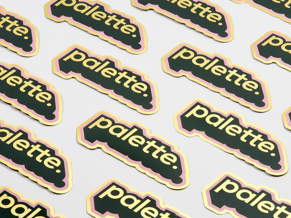 A collection of customized gold metallic stickers in the design and shape of the word 'palette'.