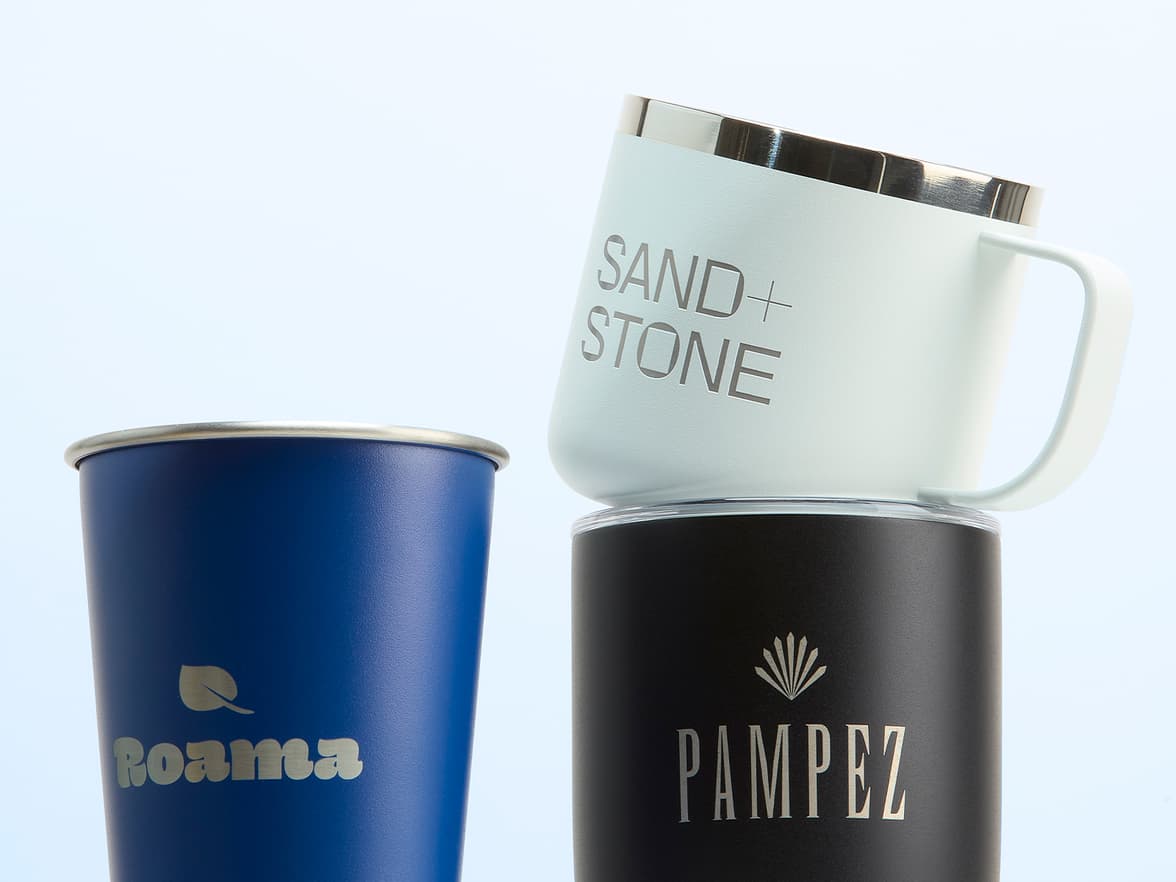 A collection of customized cups and mugs in front of a pale blue background.