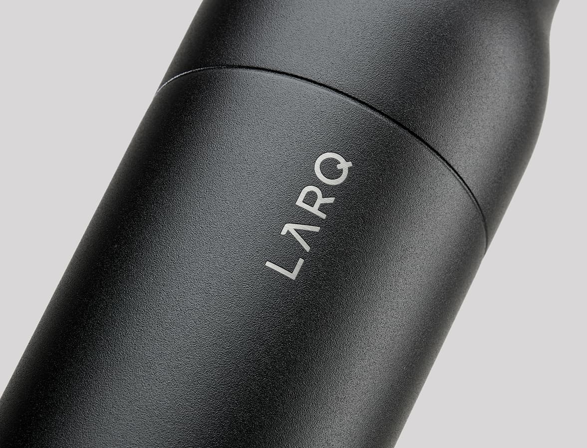 A close-up of a matte black bottle. The word LARQ is debossed on the bottle. 