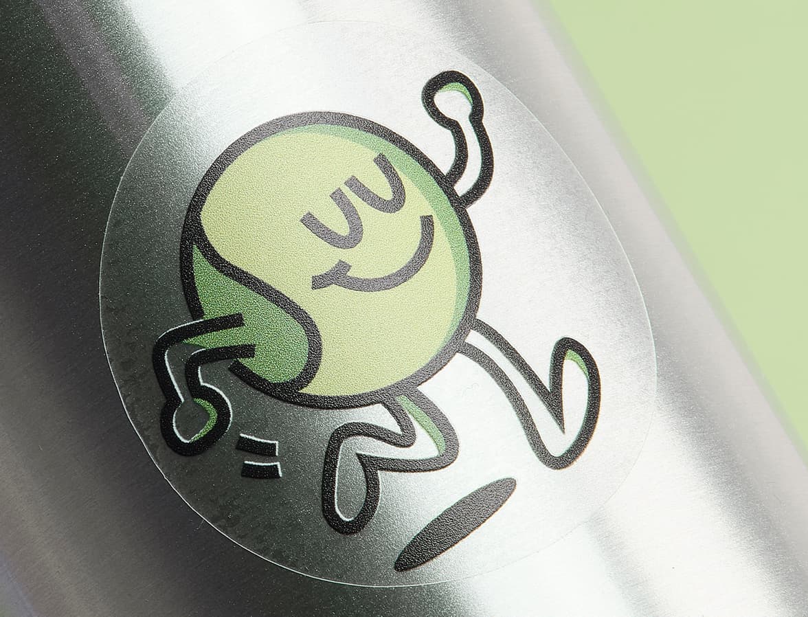 A customized clear round sticker with a green cartoon character printed on it.