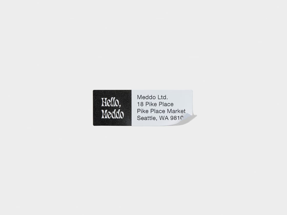 A rectangular white and black return address label with branding on the left side and the address on the right.
