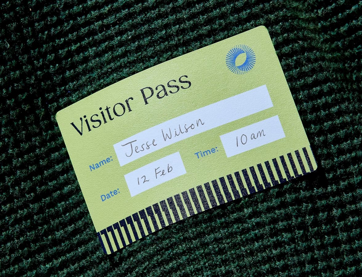 A green customized visitor pass sticker.