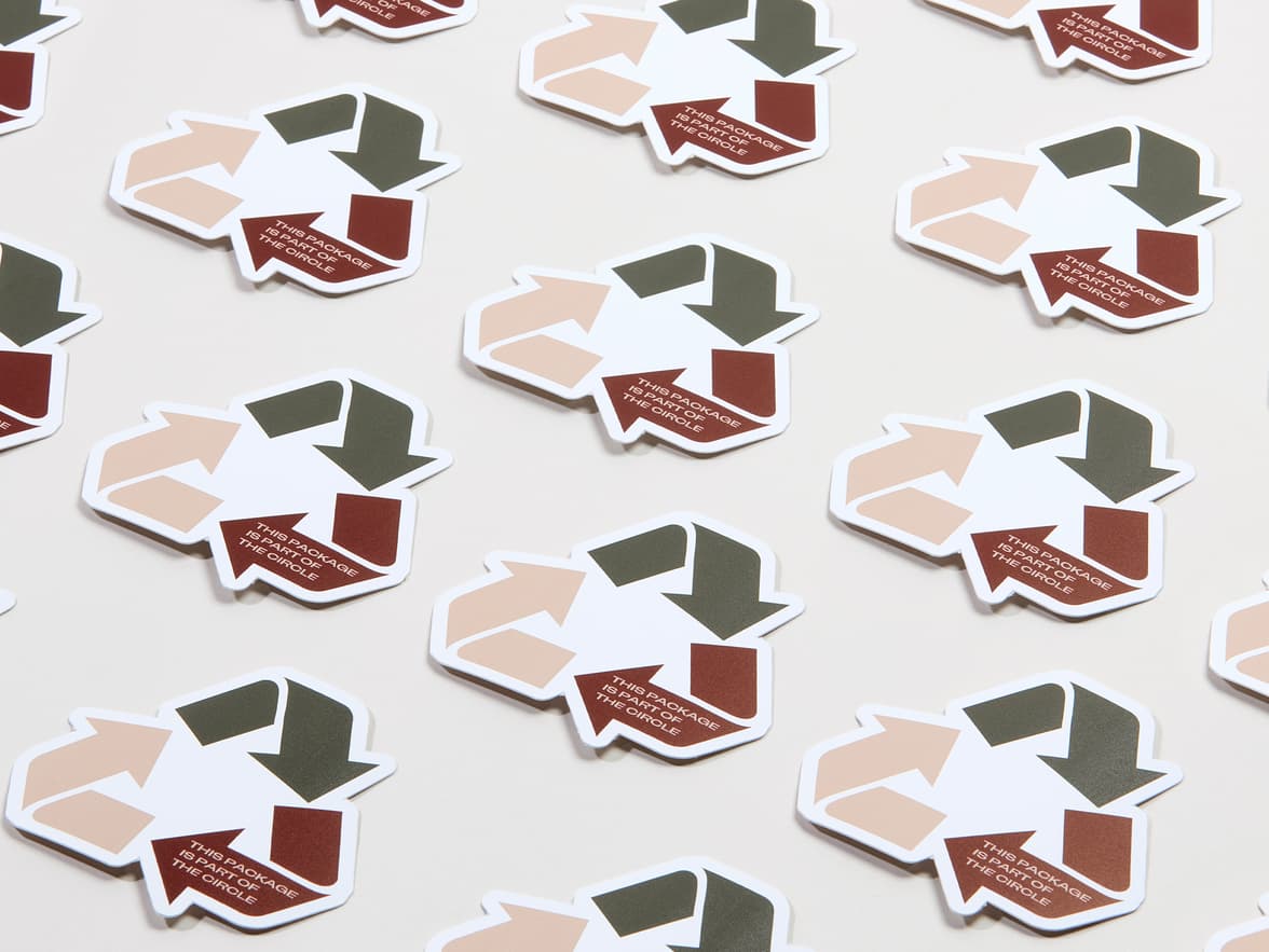 A collection of customized coated stickers in the shape of the recycling triangle.