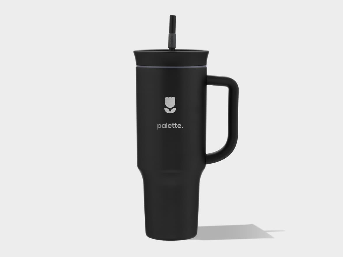 A black tumbler with a handle, straw, and "palette." branding.