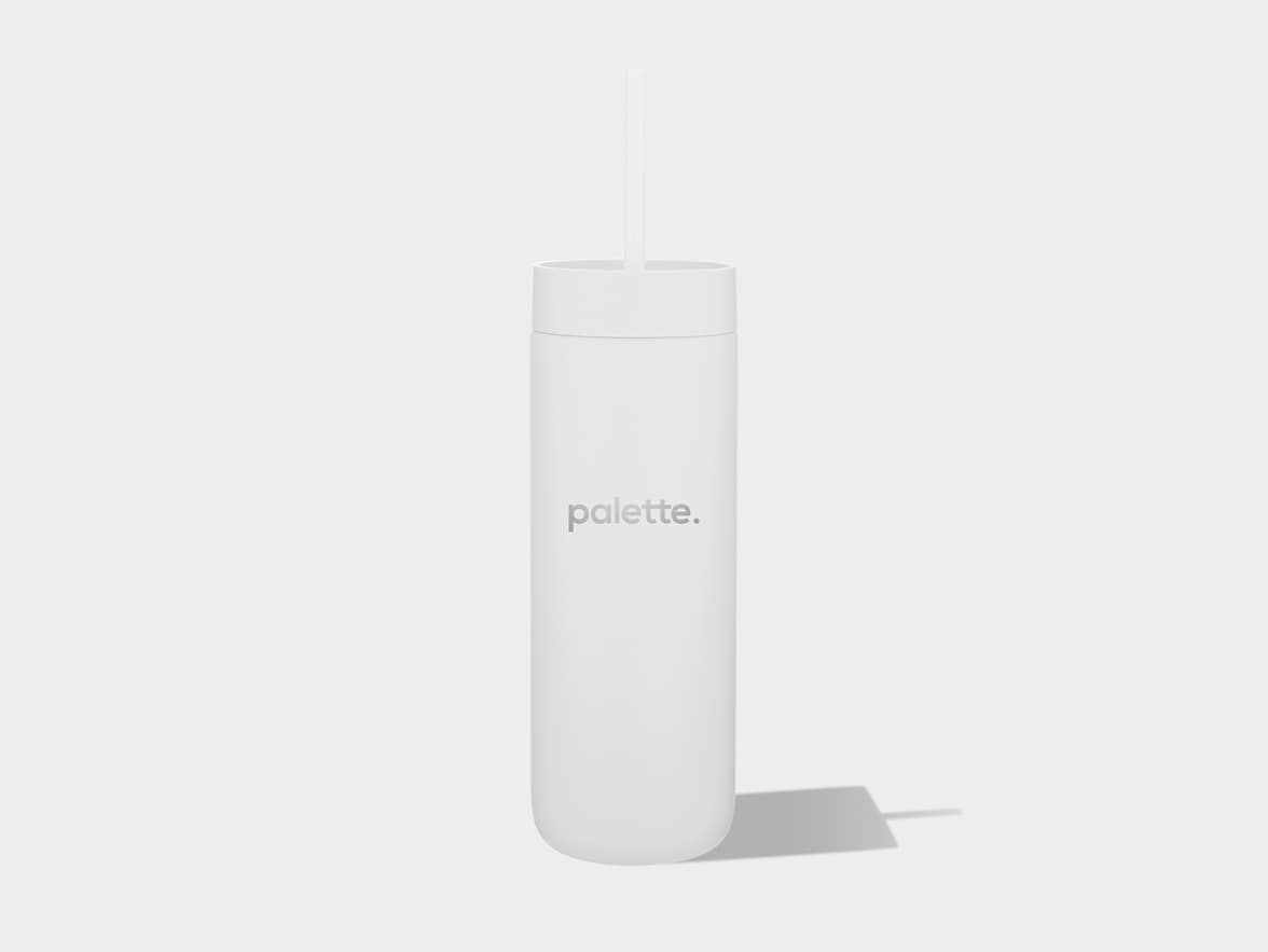 A white cylindrical tumbler with a straw protrudes from its lid, casting a subtle shadow to the right on a light grey background. The word "palette." is printed horizontally in a light grey font on the front of the tumbler.