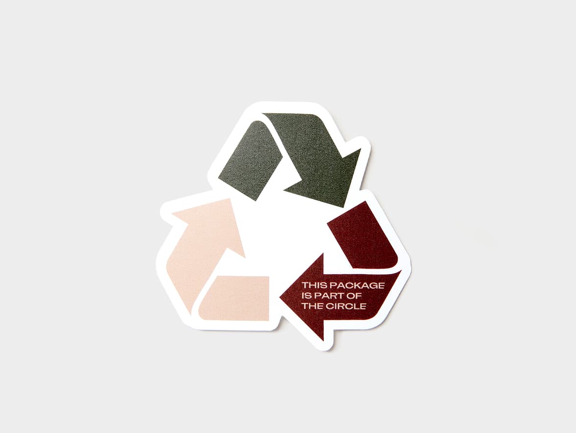 A customized coated sticker in the shape of the recycling triangle.