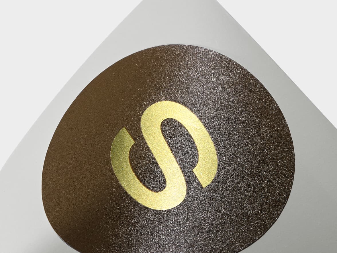 A close up image of a customized round gold metallic sticker.