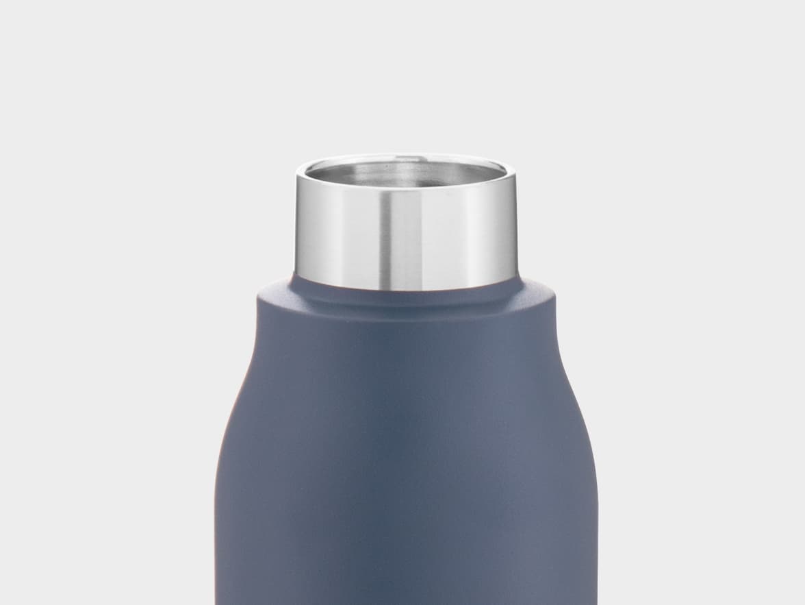 Close-up of the top of a matte slate blue insulated water bottle with a shiny silver metal rim against a light gray background.