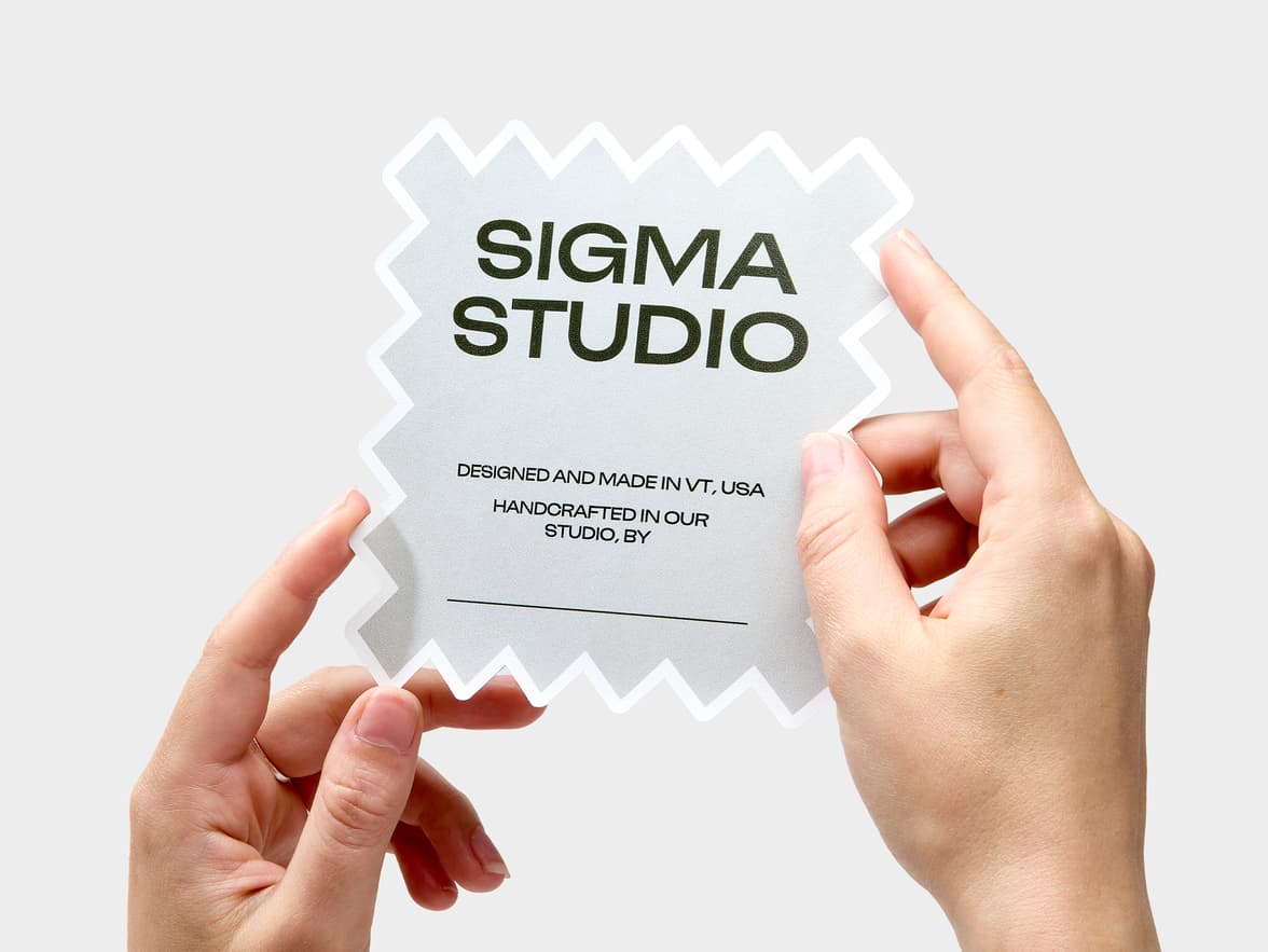 A hand holding a customized square sticker with jagged edges.