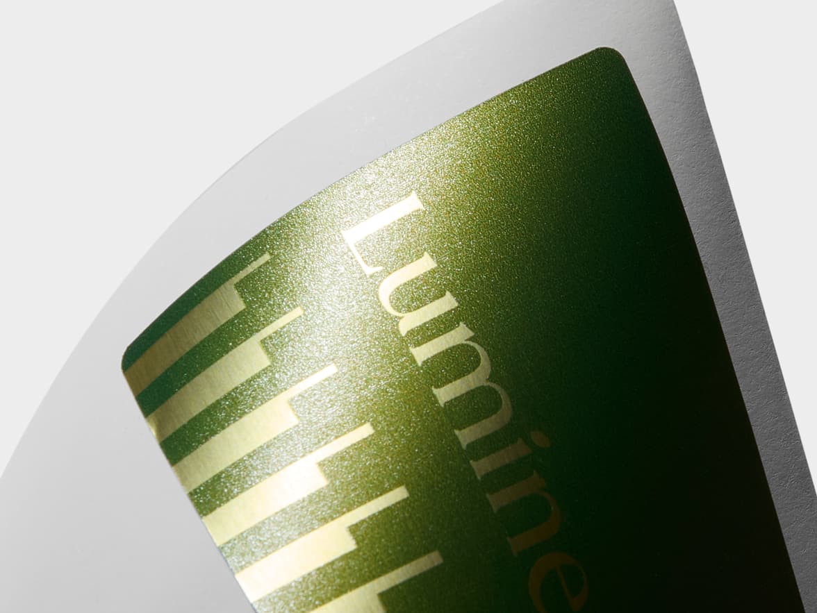 A close up image of a rectangular gold metallic sticker with green customization.