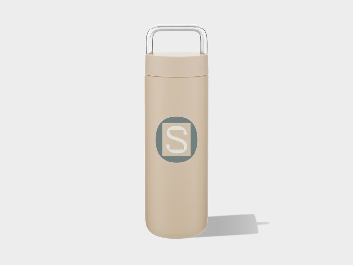 Beige tumbler with a clear handle, featuring an 'S' logo in a square within a circle.