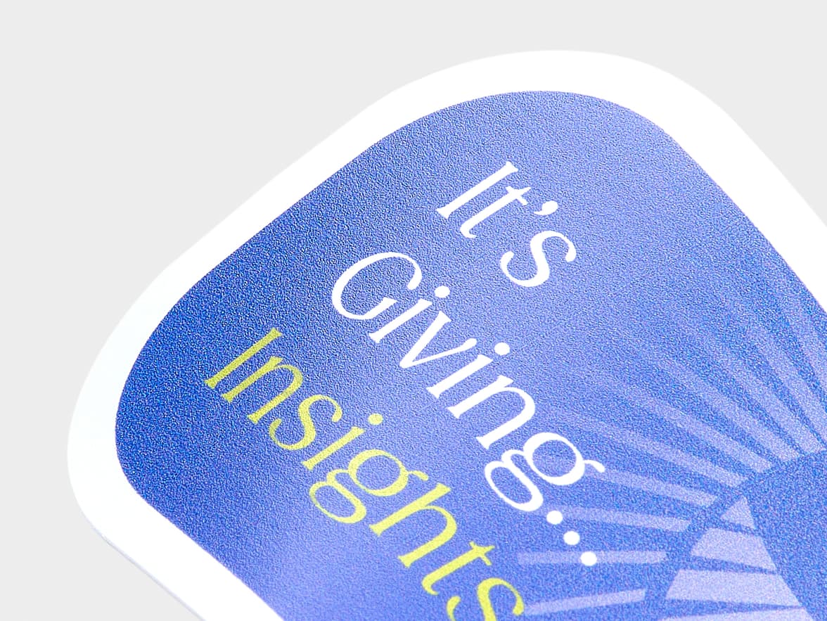 A close up image of a coated sticker in the shape of a speech bubble.