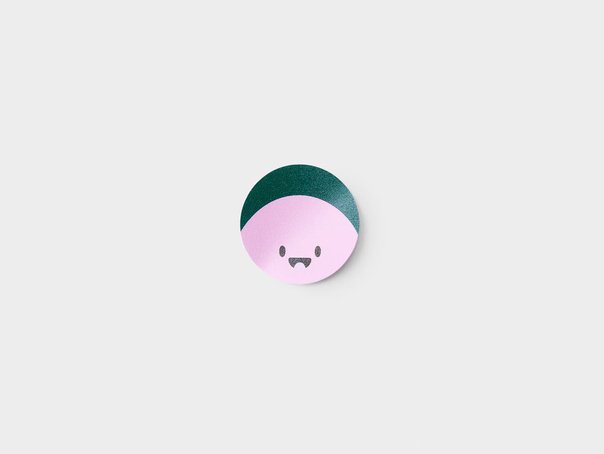 A customized round coated sticker with a animated face printed on it.