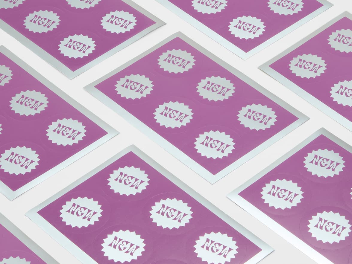 A collection of round silver metallic stickers with purple customization.