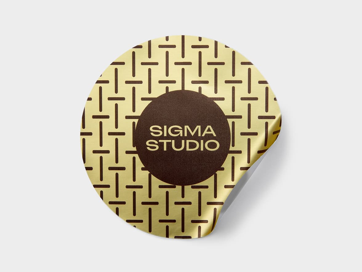 A large round gold metallic sticker with brown customization.
